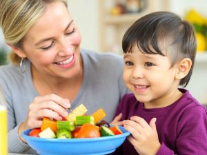 Părinte și copil mănâncă fructe sănătoase împreună.